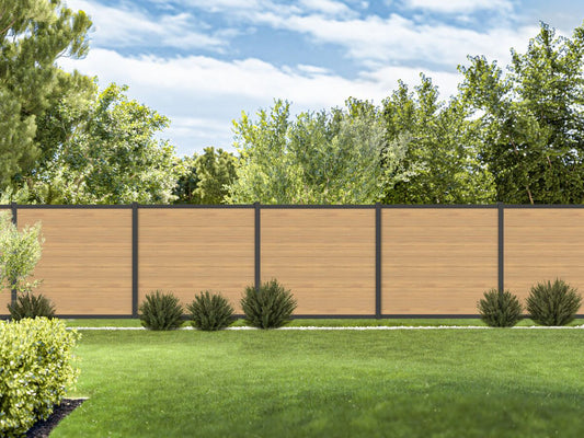 Wooden privacy fence with green grass and trees in the background